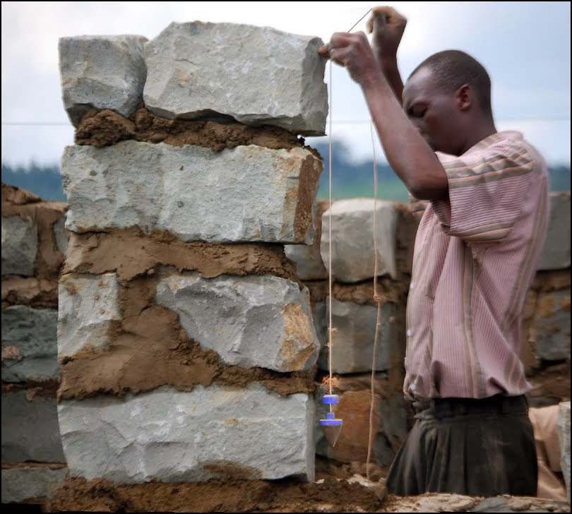 上图:一位非洲人吊起准绳筑墙。