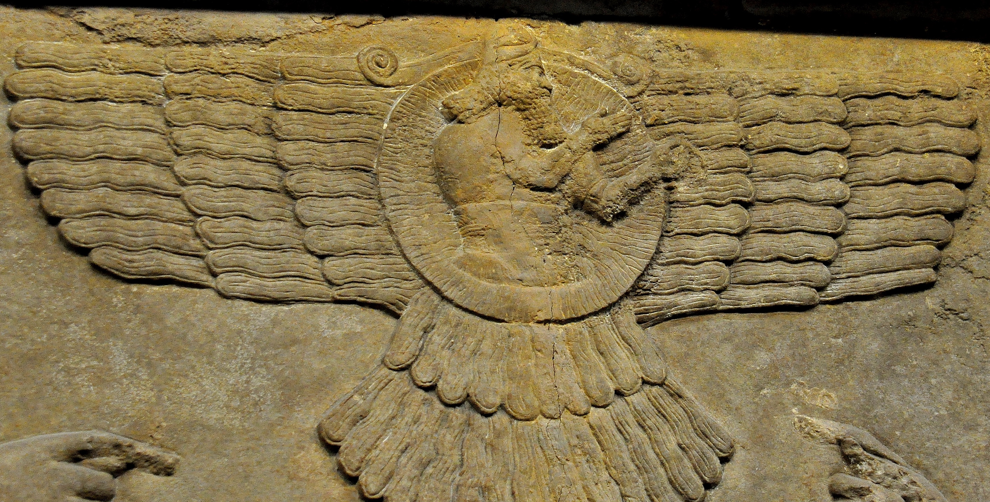 上图：宁录出土的亚述帝国主神亚述（Ashur）浮雕，形象是带翅膀的太阳，可能是用翅膀来代表光线。