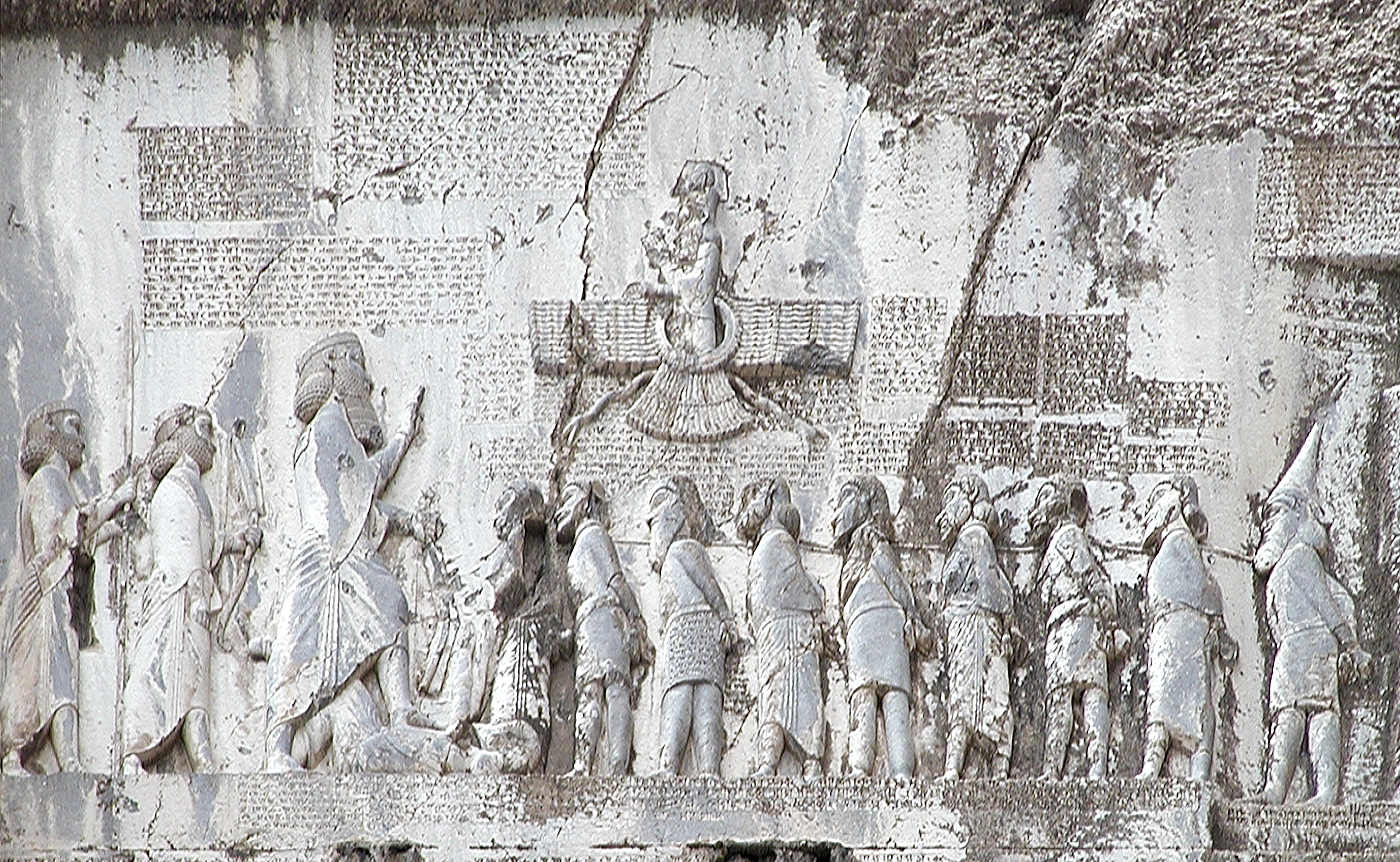 上图：贝希斯敦铭文（Behistun Inscription）是刻在伊朗贝希斯敦山崖上的多语言铭文，由波斯阿契美尼德帝国大流士一世所立，记录了他镇压高墨达（Gaumata）政变和各地反叛、取得王位的经过。石刻上有描绘大流士一世脚踏高墨达的浮雕，周围的铭文以三种不同的楔形文字写成：古波斯语、亚兰语和巴比伦语。这个石刻有如罗塞塔石碑之于埃及象形文字一样，极大地帮助了专家们破解楔形文字。1835年，英国人罗林森（Sir Henry Rawlinson）拓取了石刻上的古波斯文铭文，1844年又拓取了其余的铭文。在他和其他学者的努力下，古波斯文铭文首先被成功解读，其它两种铭文随后也被成功解读。
